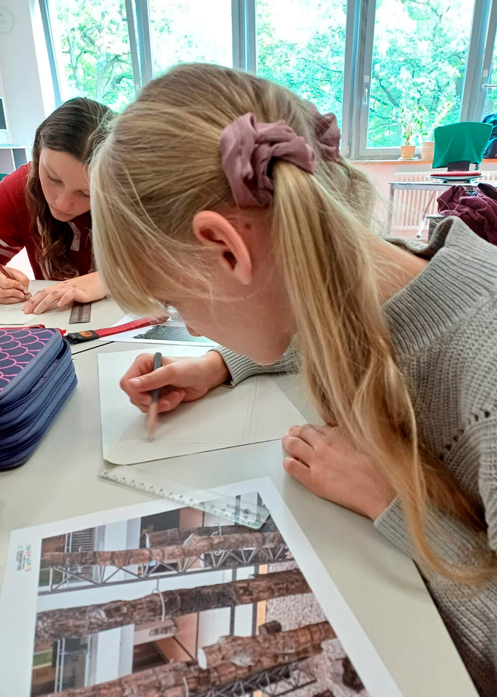 Lana zeichnet die versteinerten Bäume nach einer Fotovorlage im Rahmen des Projektes "Chemnitzer Bauwerke werden zu tragbaren Kunstwerken"